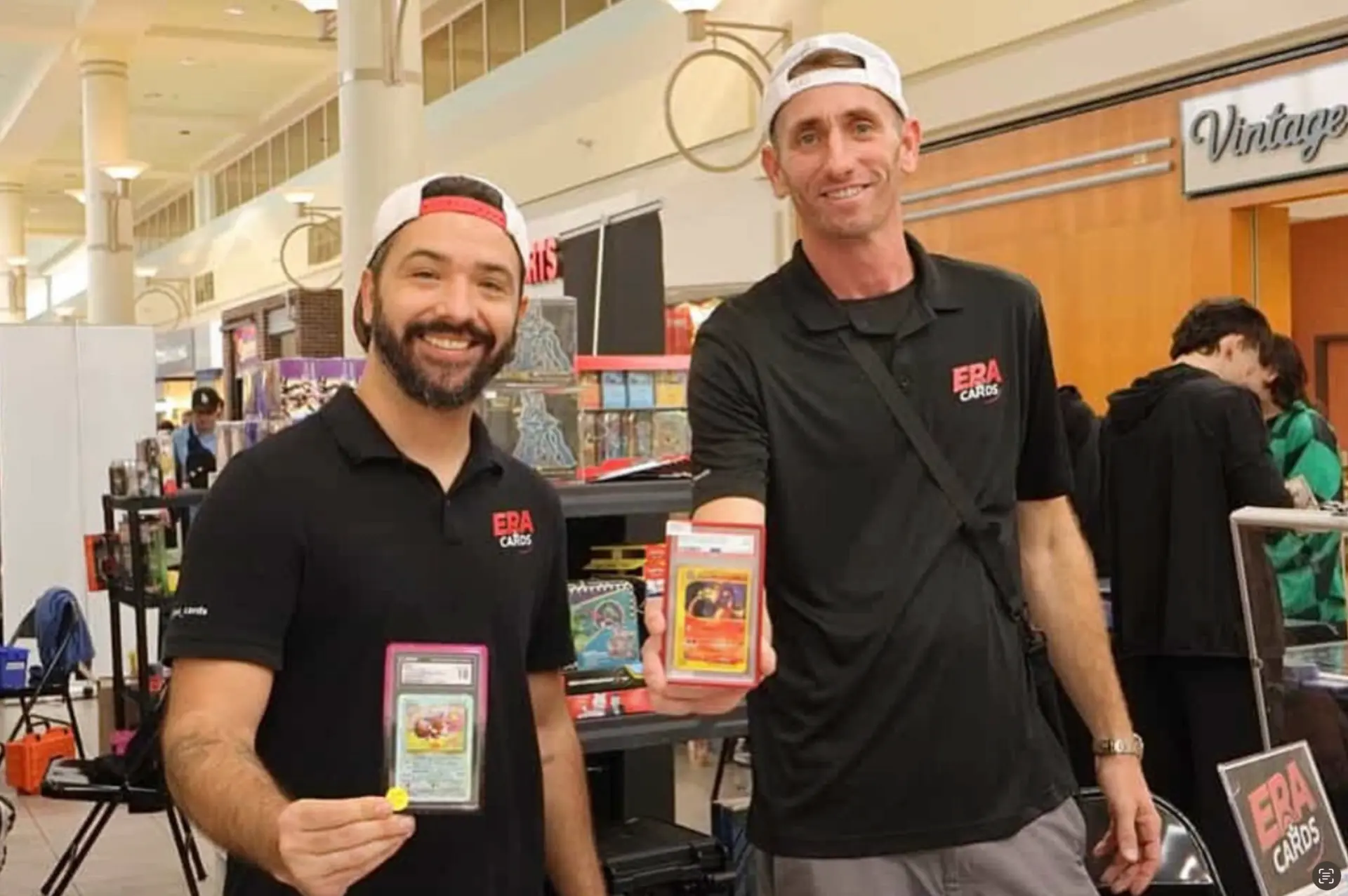 The ERA Cards team holding graded Pokémon cards at their booth