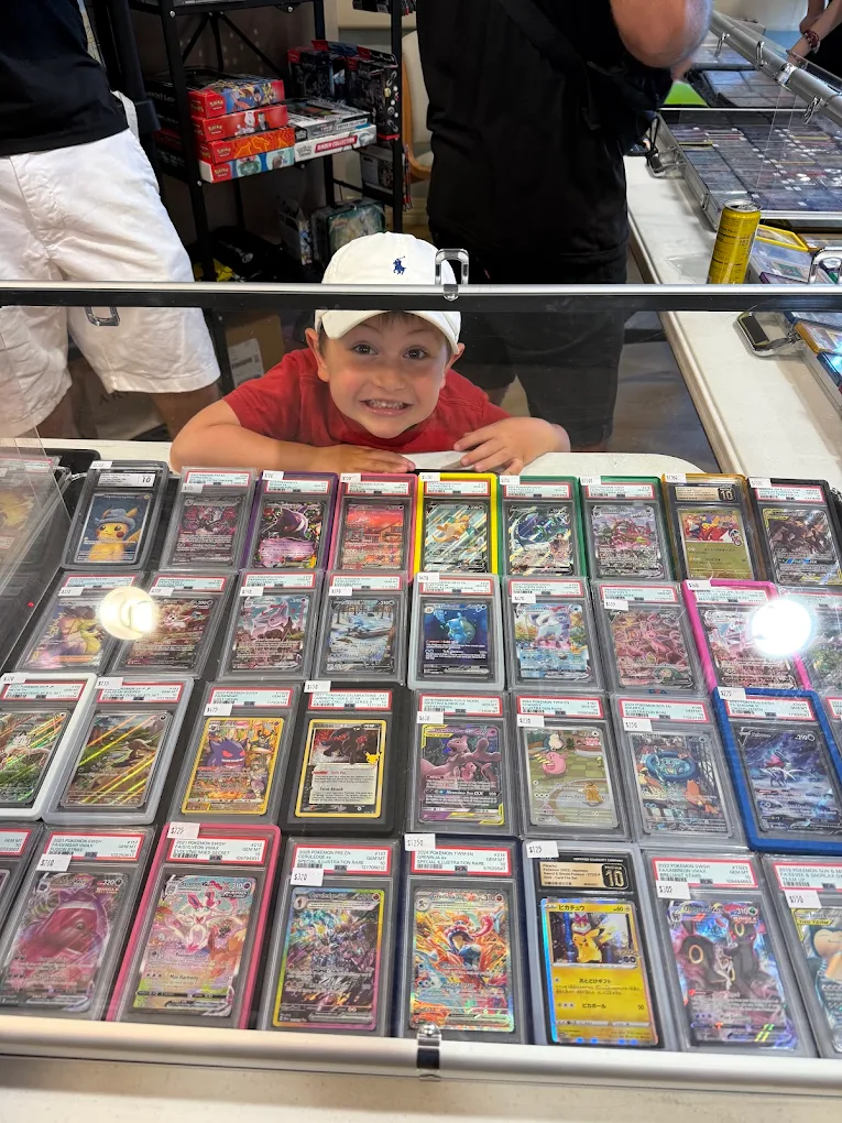 A young collector looking over a case of graded Pokémon cards at the ERA table